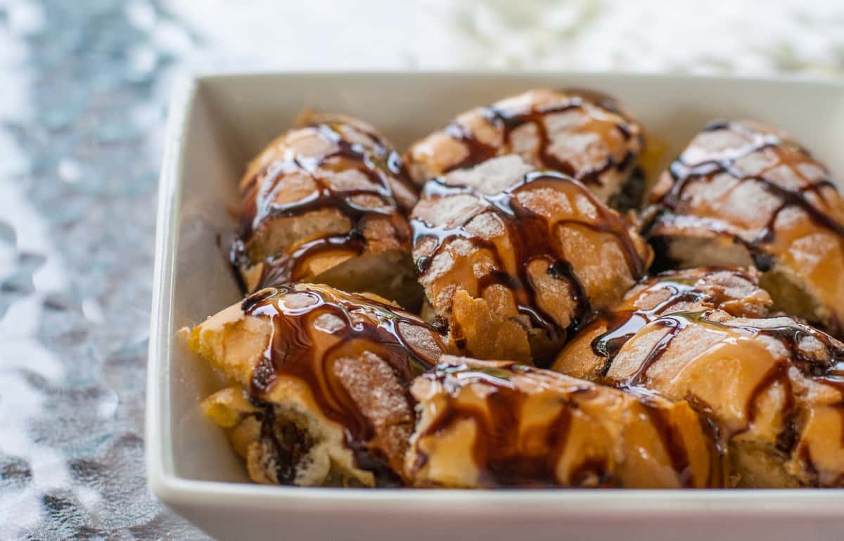 Tray of pastries drizzled with chocolate and icing.