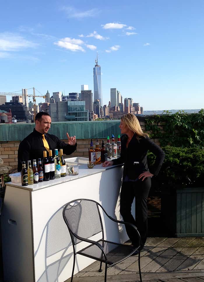 two employees standing by a bar on a rooftop