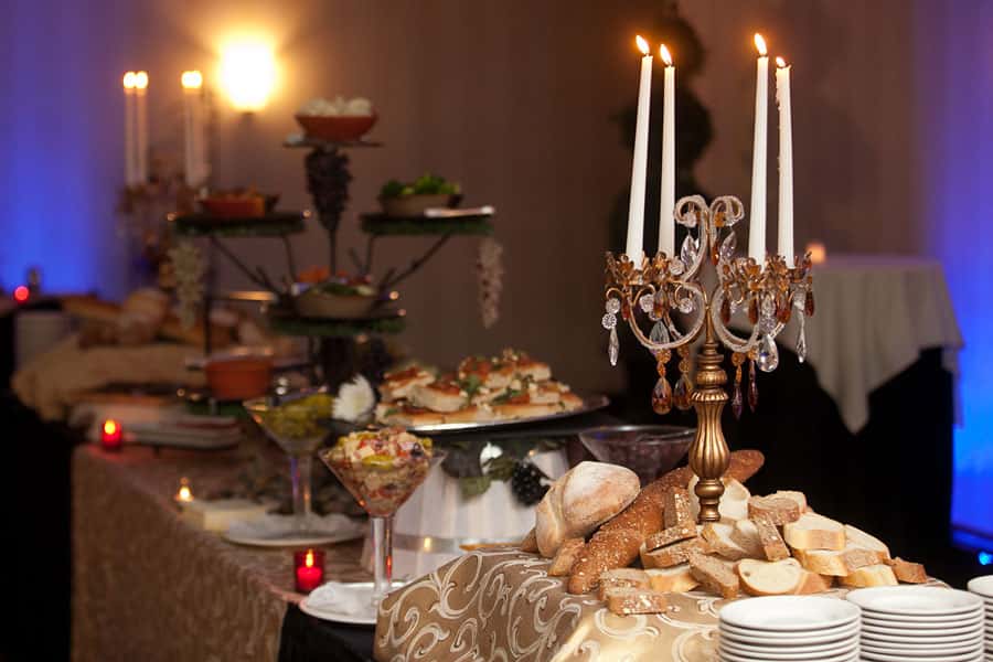 bread and appetizers on a table with a variety of dips and a candelabra with four candles