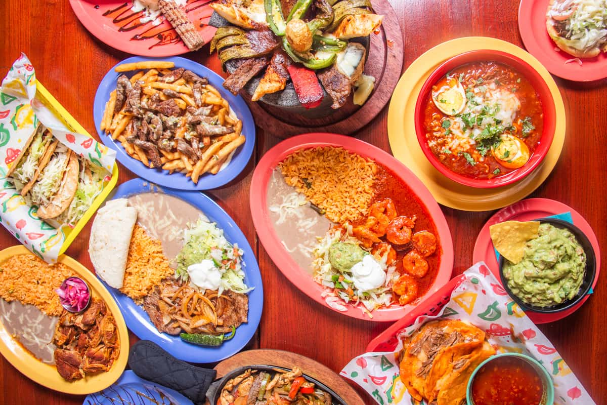 Table spread of shareable El Cazo Mexican dishes for a group gathering