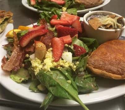 salad with strawberries, bacon and eggs springled on top