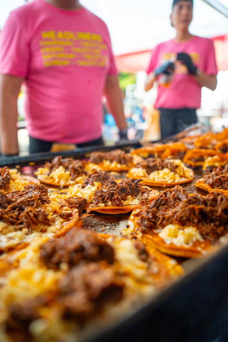 Sizzling quesabirrias on a flat grill at a catering event in Chicago