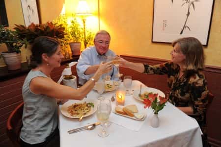 Guests dining at a table toasting with wine glasses