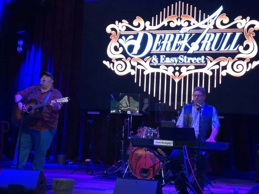 Derek trull on left singing and playing guitar, Chris Nordman on right playing piano and singing