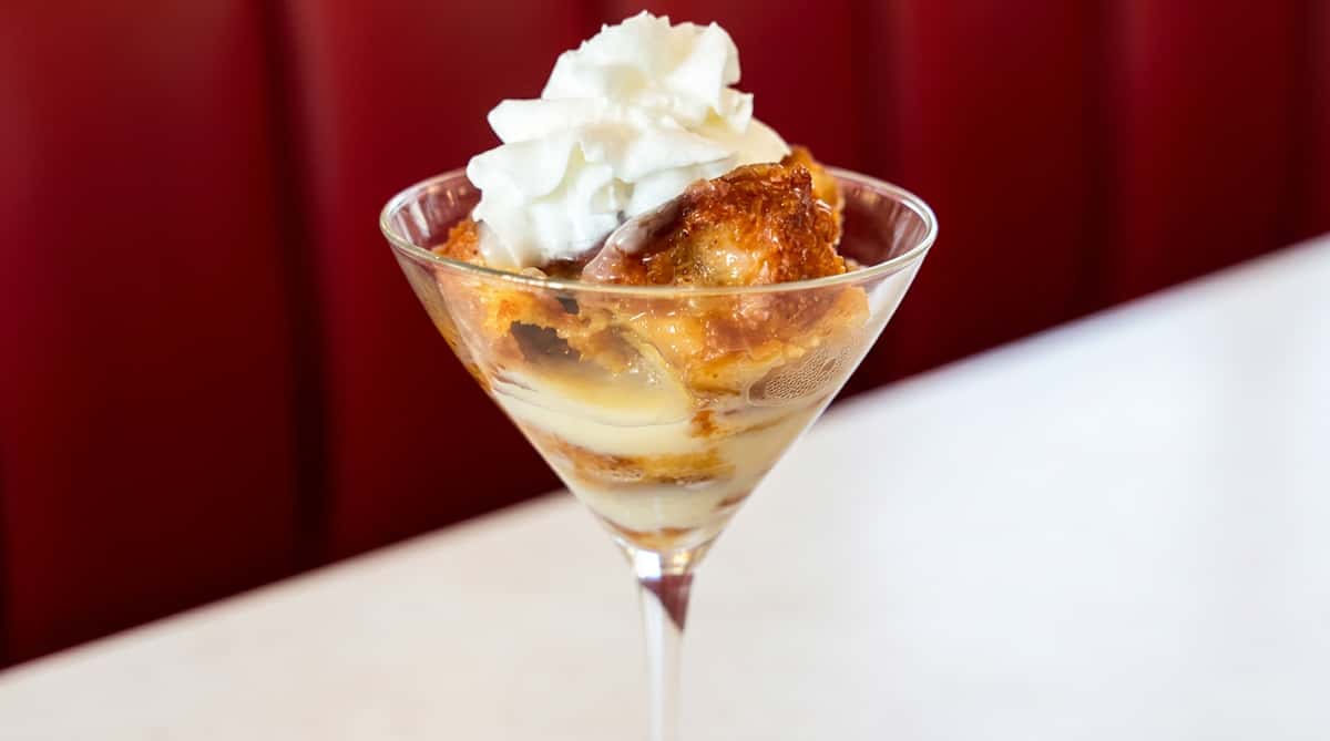 Layered trifle dessert topped with whipped cream at Woody's Burgers and Bugs