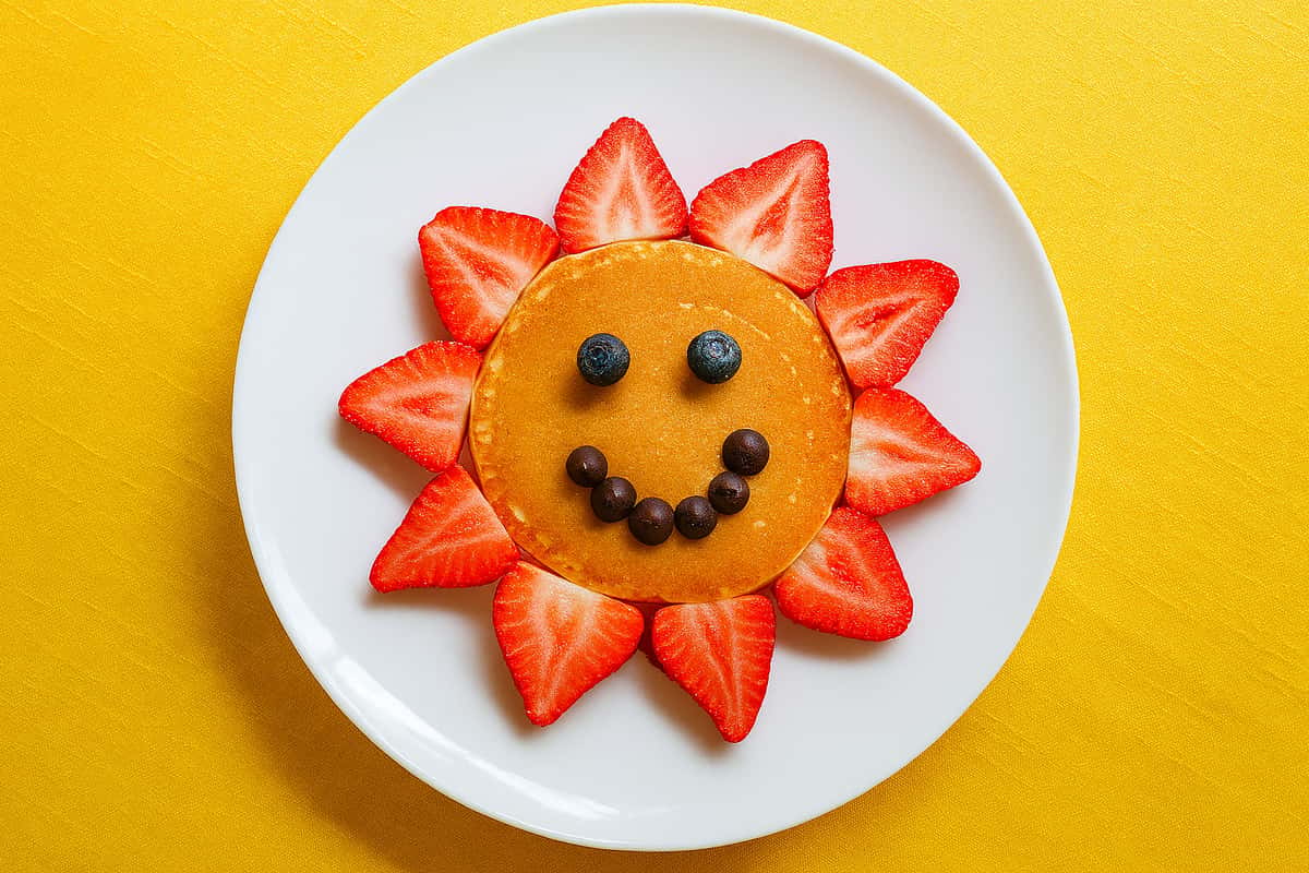Pancake with blueberry smile and strawberries