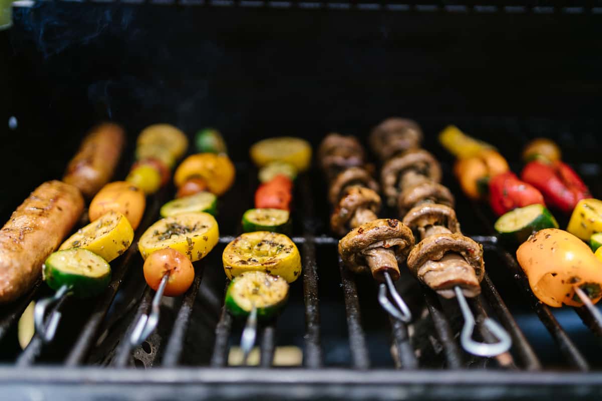 close-up-of-a-bbq-grill-with-colorful-veggies-and-sausage-sk