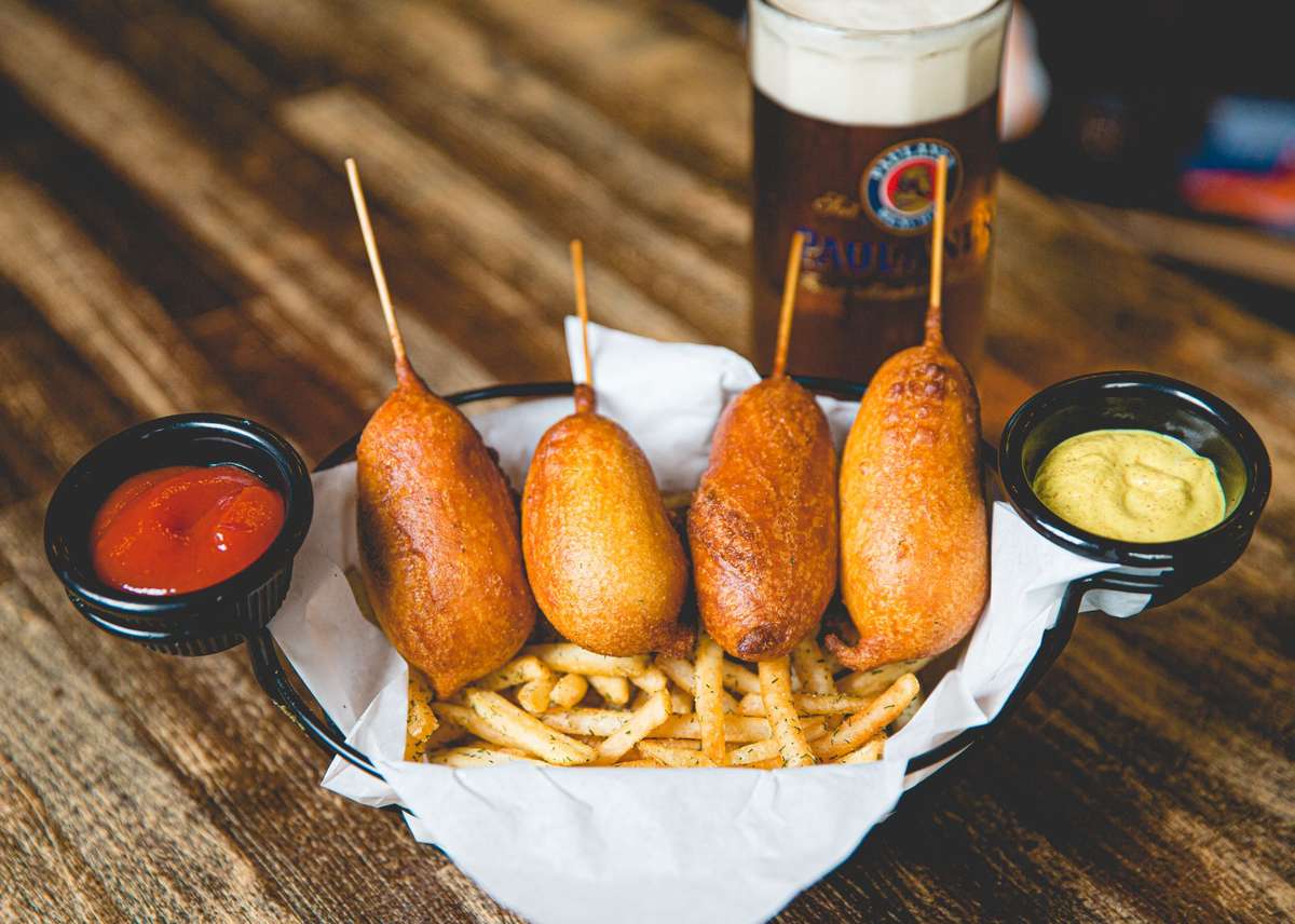 Golden mini corn dogs served with crispy French fries and dipping sauces, a classic pub appetizer at Berliner Pub.