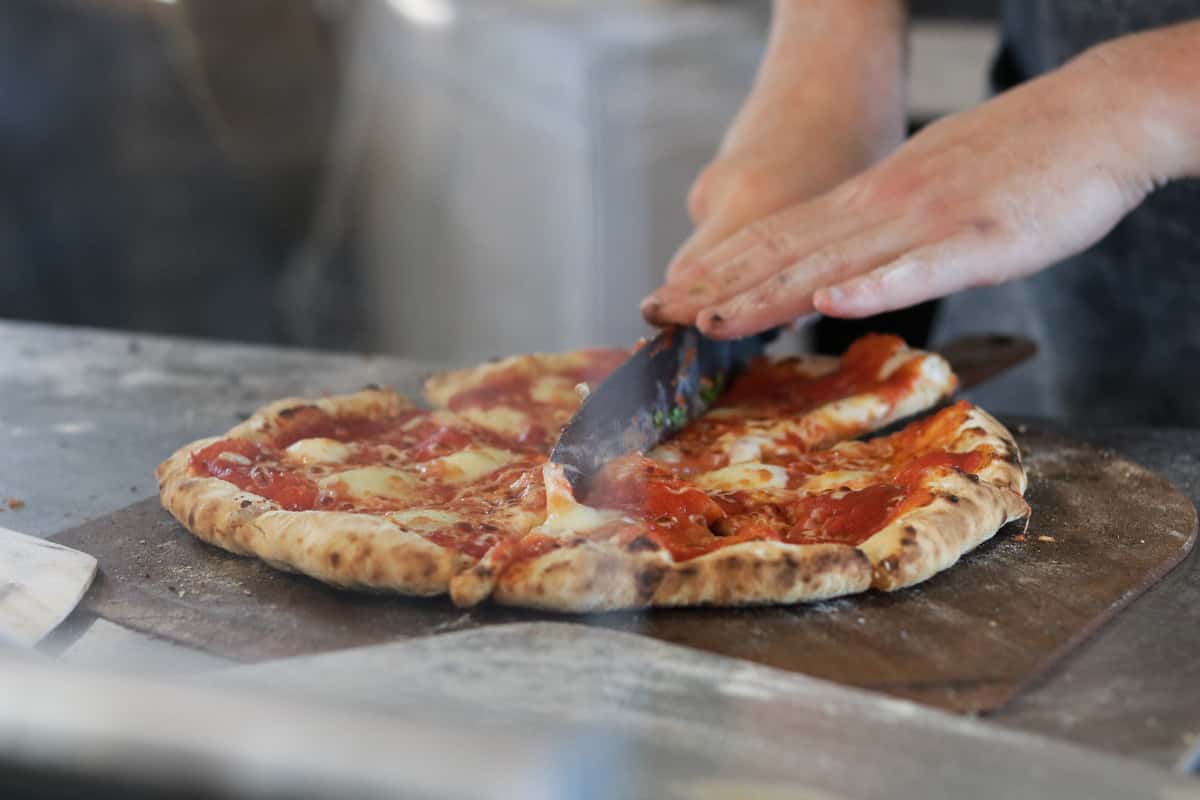 Person cutting a pizza.
