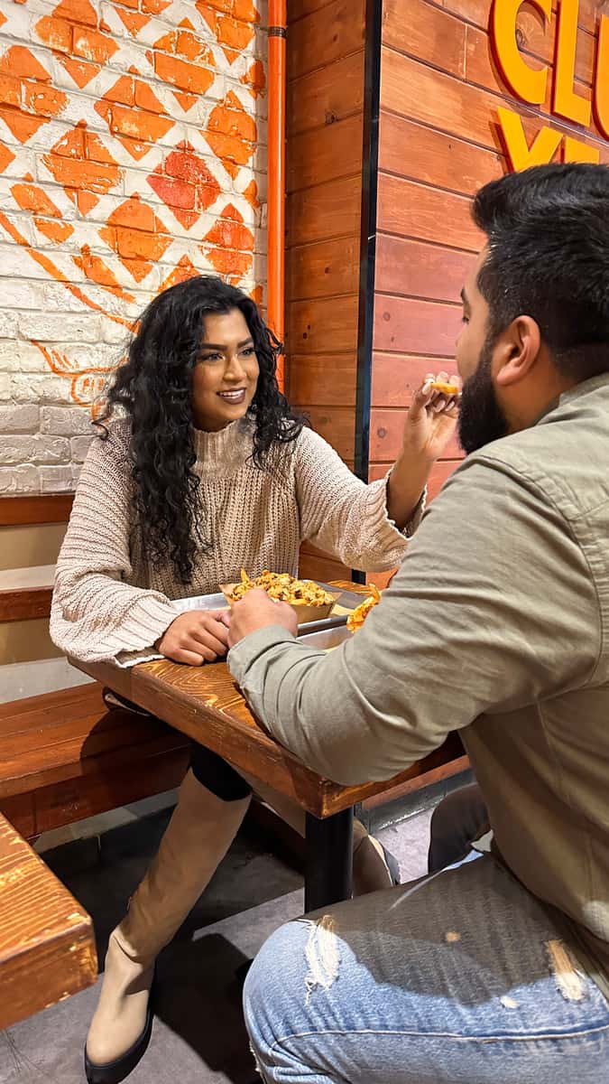 Two people eating a meal inside a Cluck Clucks location