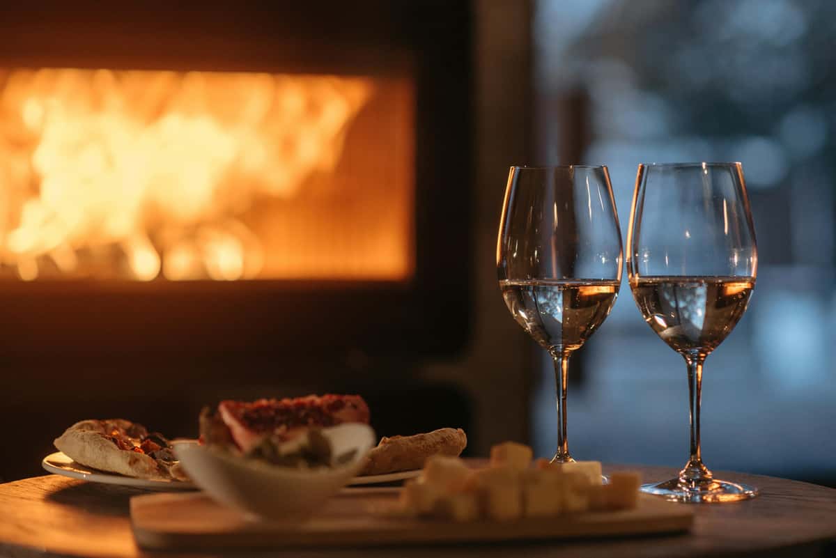 Cozy dining at City Limits Bar & Grill with wine glasses, appetizers, and a warm fireplace.