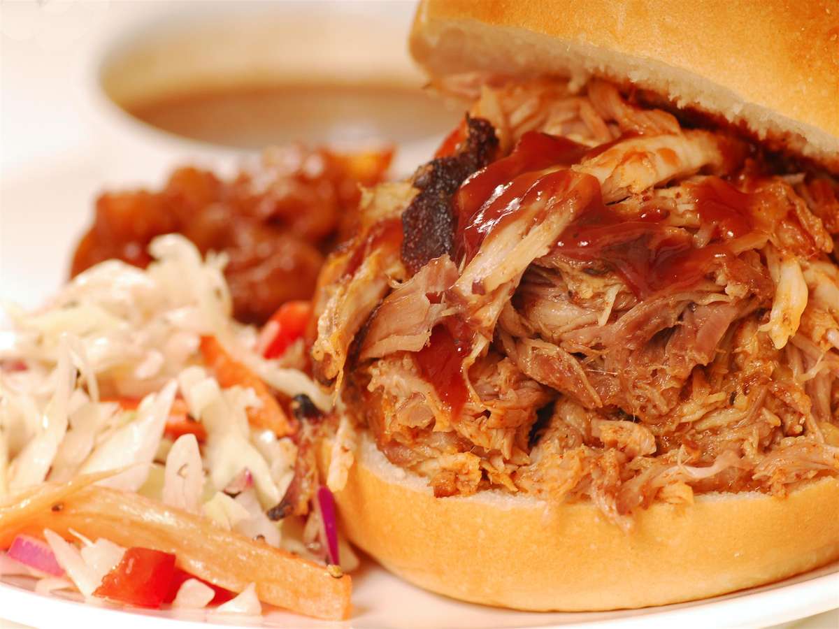 pulled pork sandwich with barbecue sauce and french fries