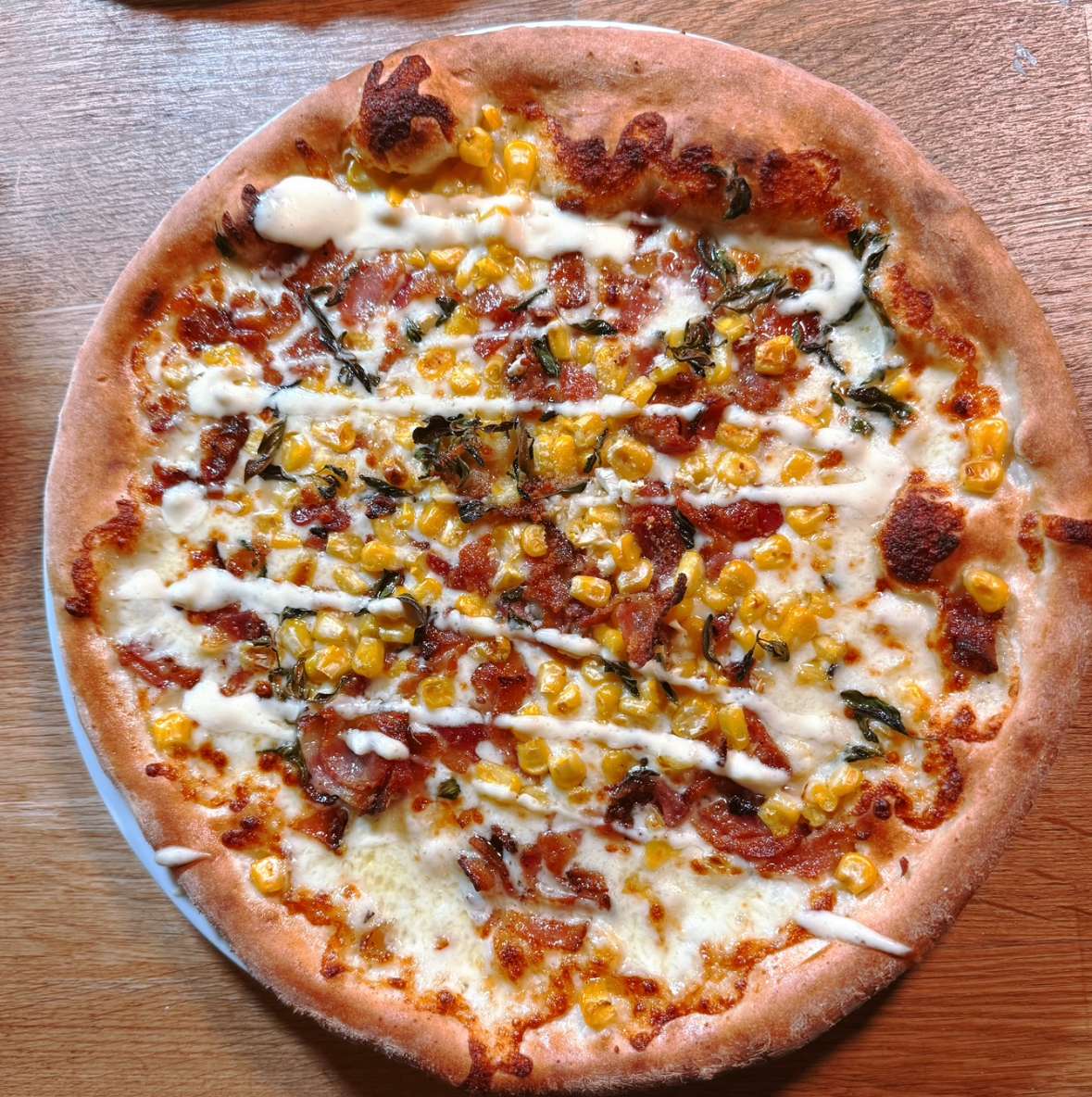 Wood-fired pizza topped with corn and herbs at The Marshal