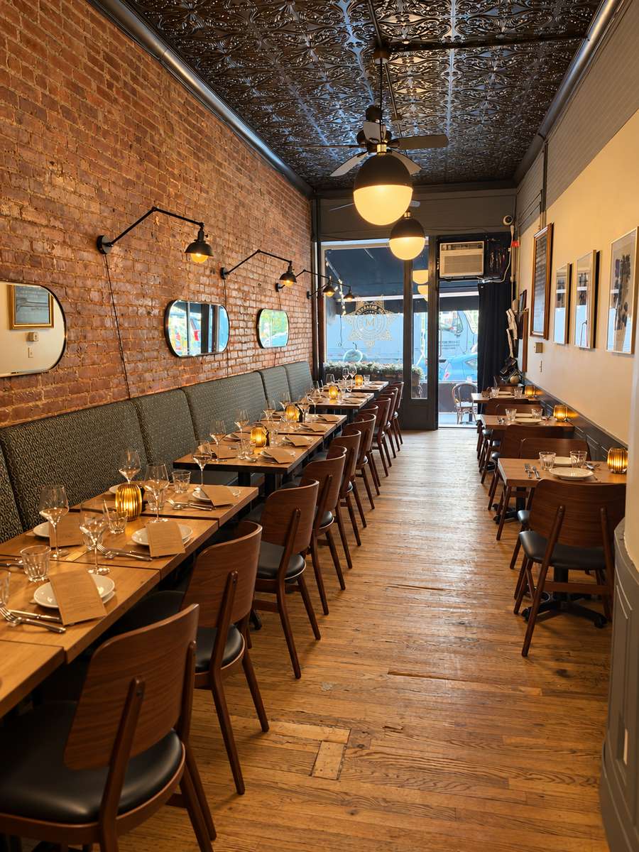 The Marshal dining room with brick walls and tables set for service