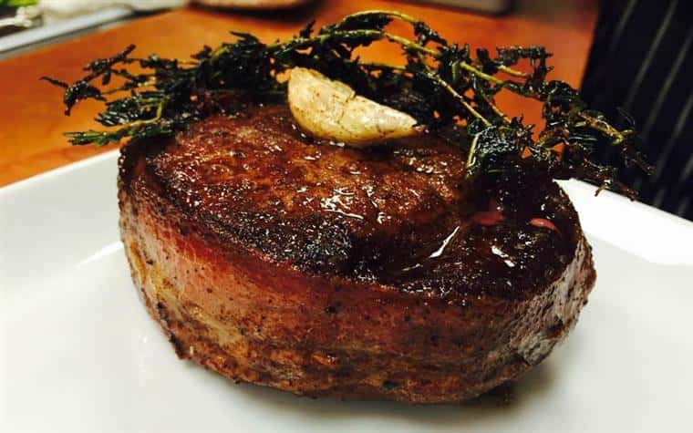Bacon wrapped steak with rosemary on a dish