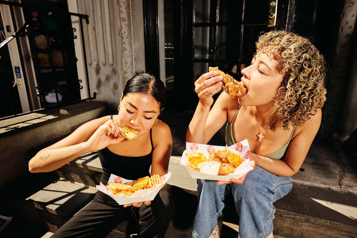 young people enjoying crispy chicken