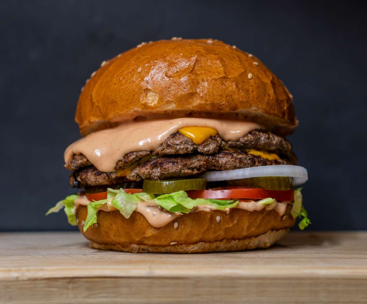 Burger on a wooden table with a dark blue background