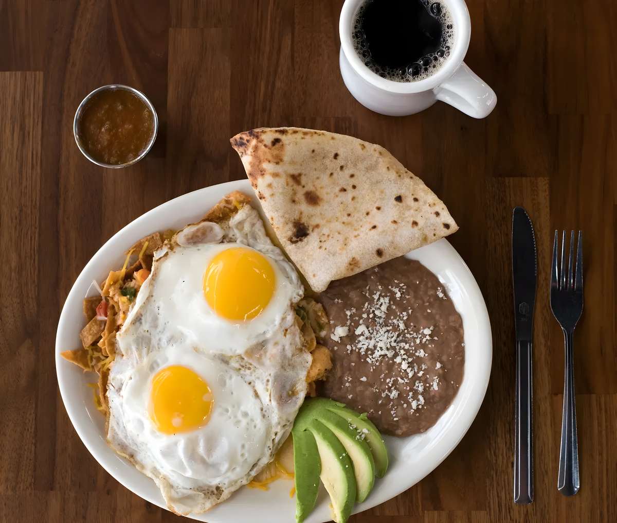 Huevos rancheros served with eggs, beans, and warm tortillas.