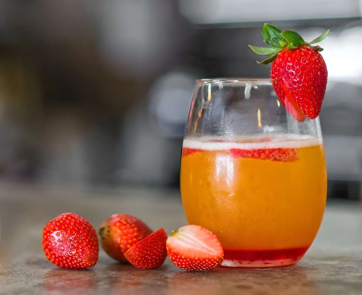 Fresh strawberry mimosa garnished with a whole strawberry.