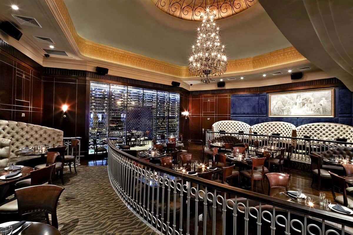 Empire Steak House East 50th main dining floor, called The Ballroom. Luxurious NYC elegance feel, velvet booths and chandelier.