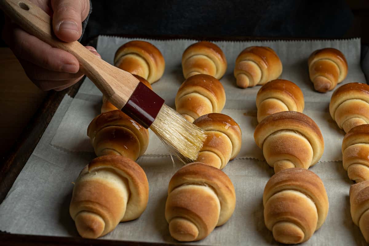 Croissants being oiled before baking