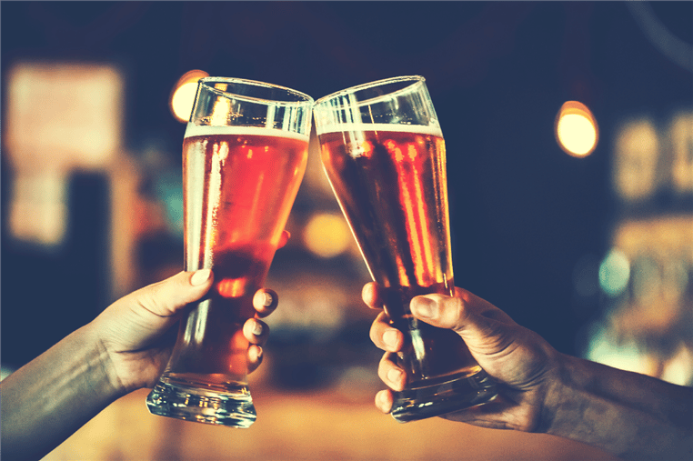 two glasses of beer being touched together