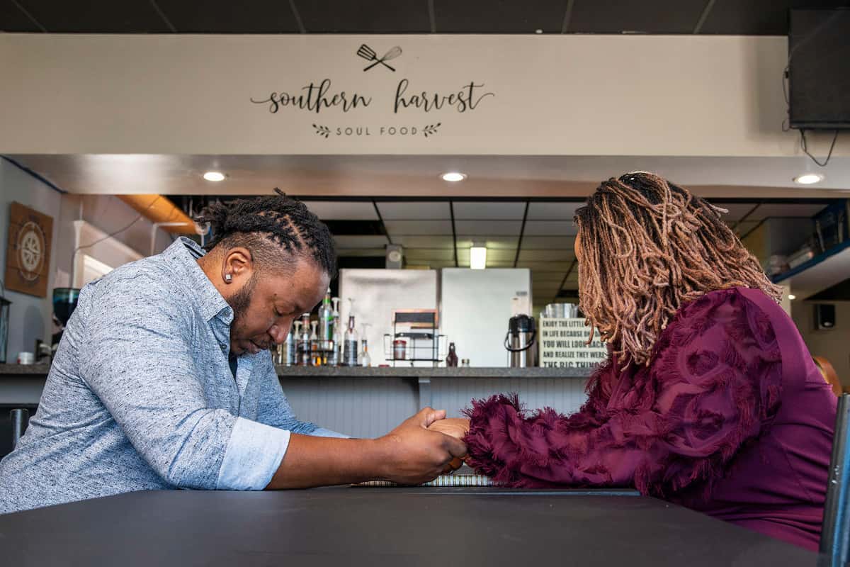 Owners praying over restaurant table