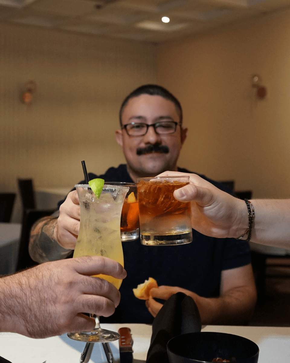 Showing guys cheer'sing 3 cocktails for guys night. 