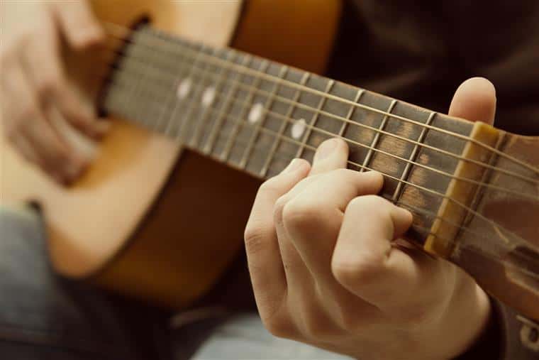 Closeup of guitarist on acoustic guitar.