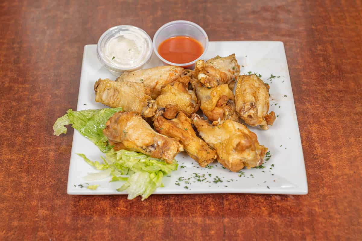 Chicken wings served with a sauce and a side