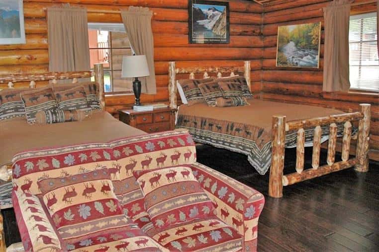 aspen log cabin indoors with two beds and a couch
