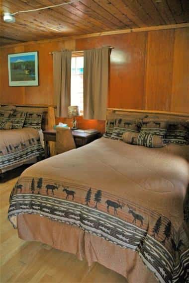 fir log cabin with two beds and a drawer