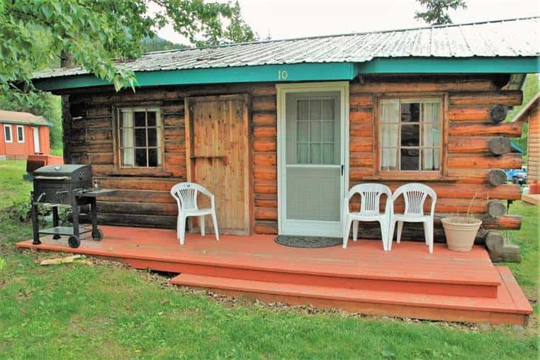 Aspen Log Cabin front porch with grill and three white chairs