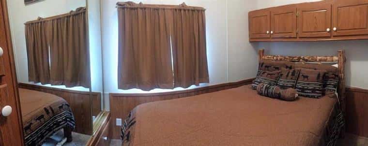 poplar chalet bed with curtains and cabinets above the bed