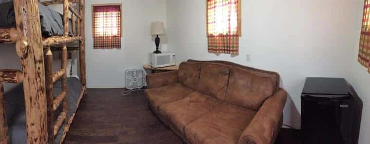 Pine Fisherman Cabin with couch, bunk beds, and cooling fan