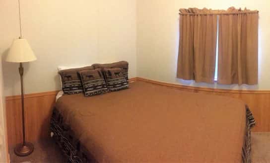 spruce chalet bed with lamp and curtains