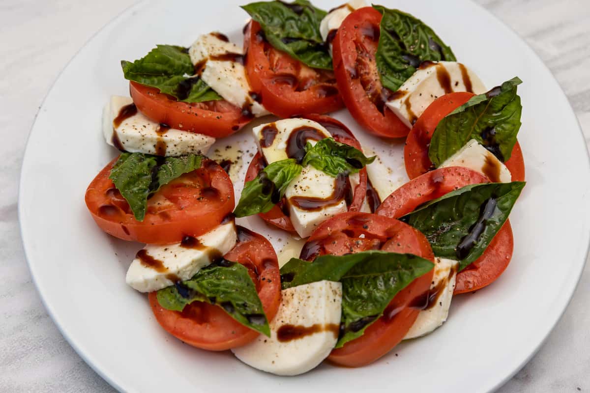 caprese salad with fresh mozzarella, tomatoes, basil, and balsamic drizzle