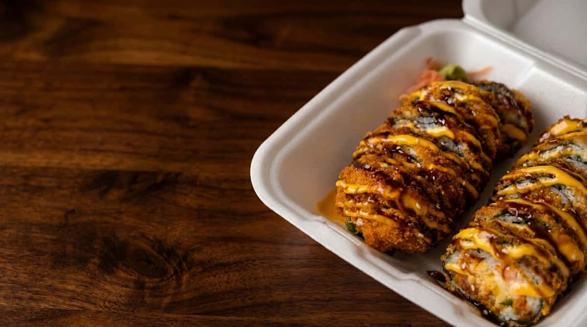 Sushi rolls drizzled with soy-based sauce and served with pickled ginger