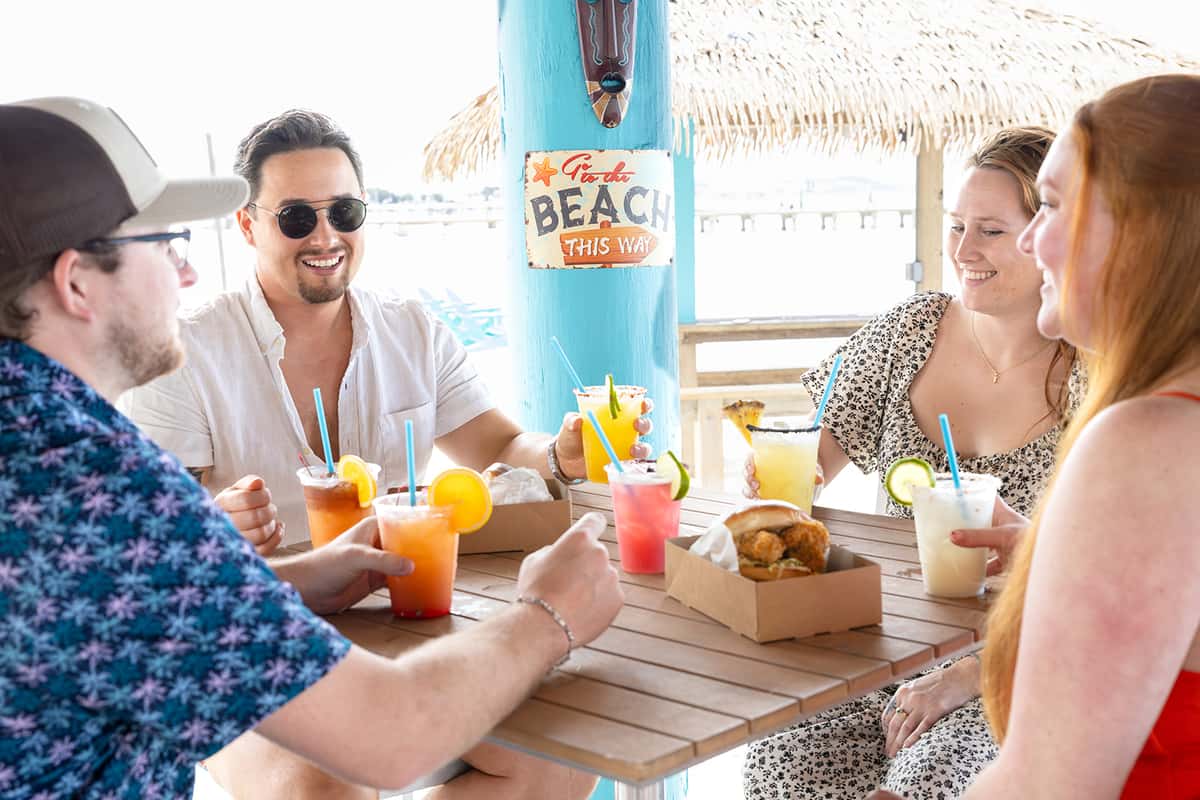 two men drinking cocktails and cheersing