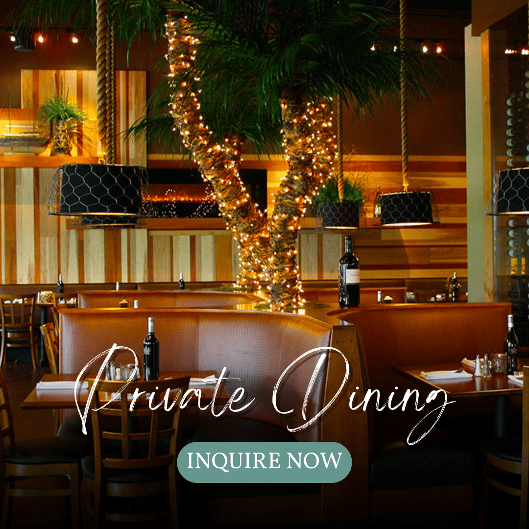 leather booths with wine bottles on the table and a light-wrapped tree in the middle - advertising Private Dining