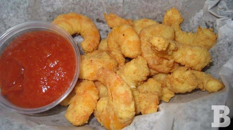 Fried shrimp with cocktail sauce in basket.