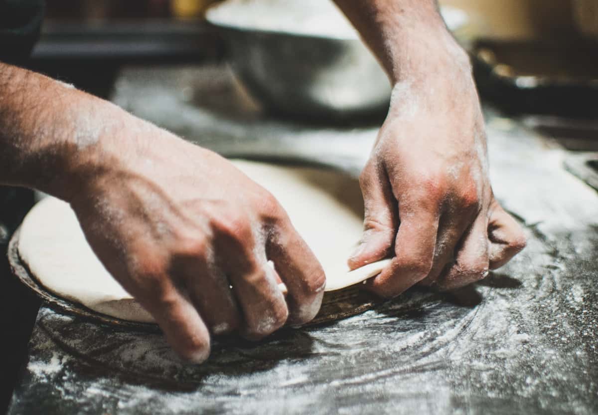 hands working pizza dough