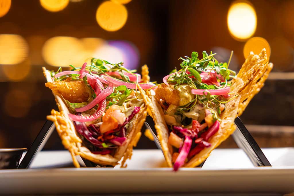 Trigger Man Tacos - Tempura Battered Chilean Sea Bass, House Slaw, Pico, Pickled Onions, Lemon Caper Aioli, Parmesan Crusted Flour Tortilla