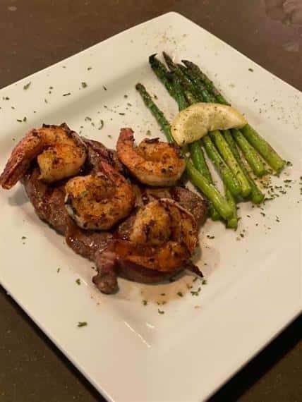 RIBEYE TOPPED WITH SHRIMP SERVED WITH ASPARAGUS