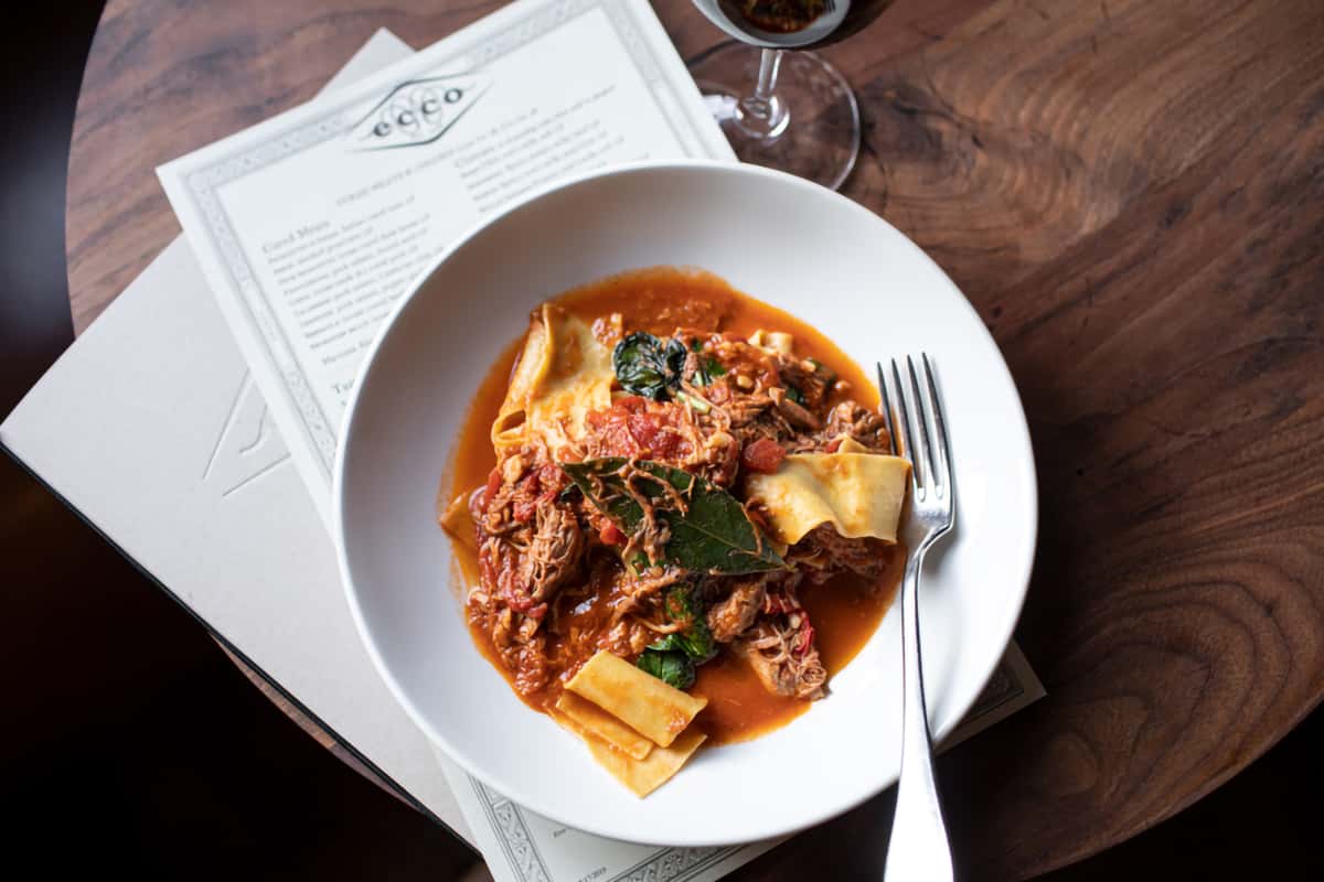 Wide pappardelle pasta served with a rich, slow-cooked ragu, garnished with fresh herbs