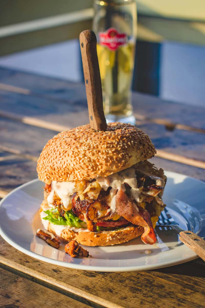 Burger with cheese, bacon, lettuce with mayo on a plate