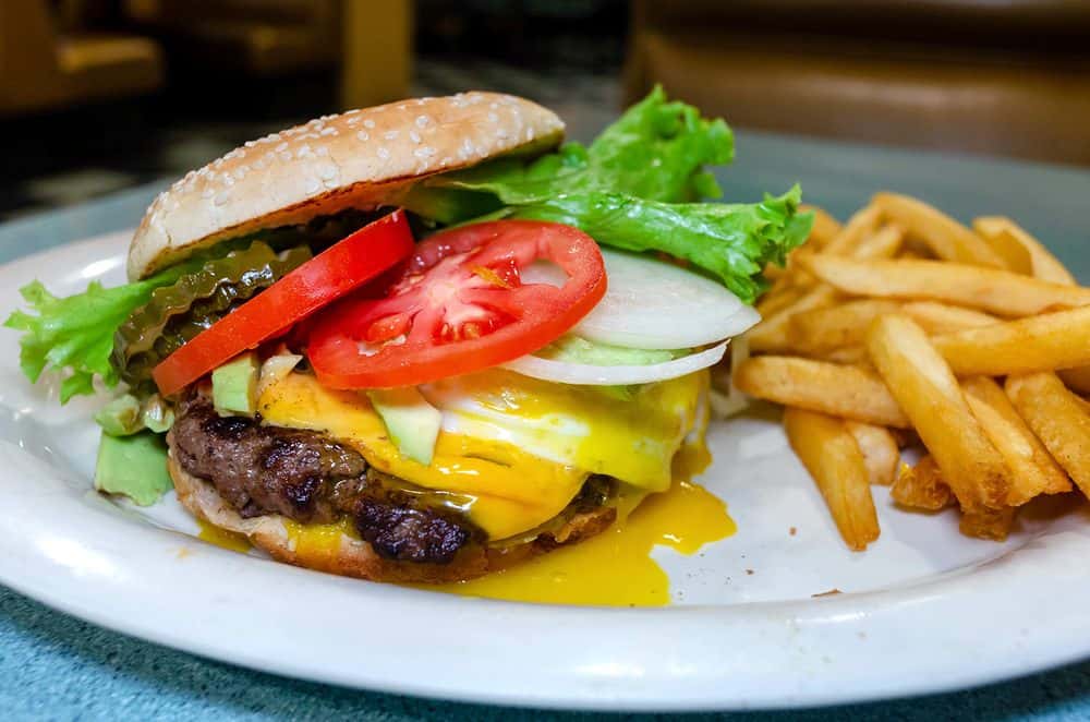 A Tennessee Grill juicy cheeseburger with fries sits on a plate.