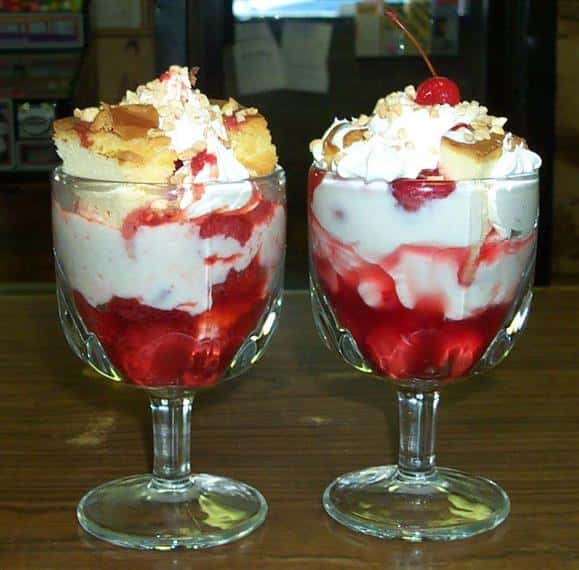 two glasses with vanilla ice cream and cherries on top