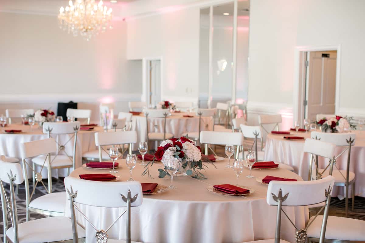 Private Event table scape with red decor and red roses and white flower centerpiece