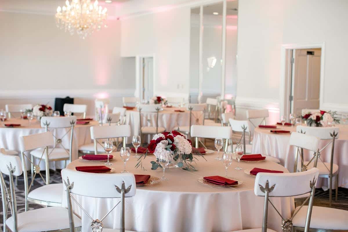 White tablescape with red napkins and red roses